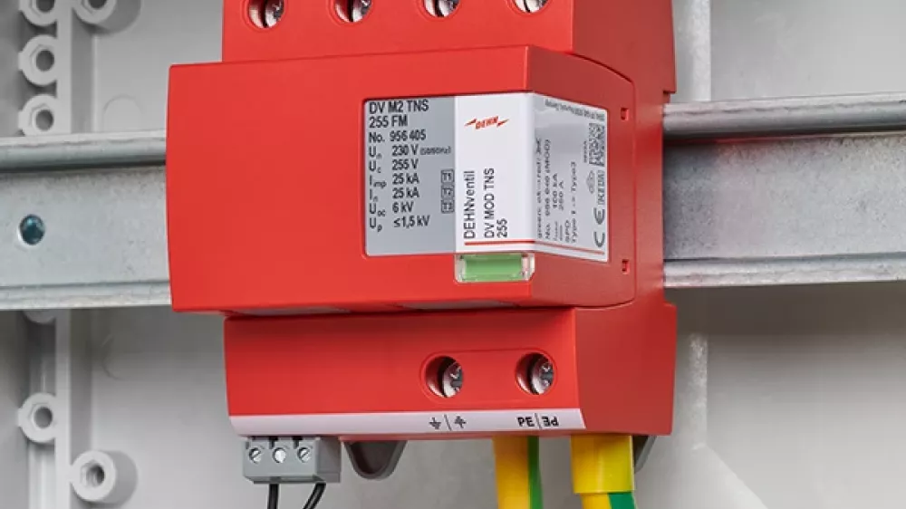 Red surge arrester, wired and mounted on a DIN rail in the switchgear cabinet.