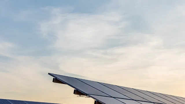 Open-field photovoltaic system on grass with sunset