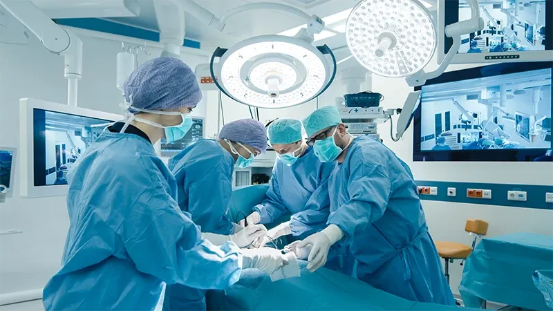 Un groupe de professionnels de la santé dans une salle d’opération, effectuant une opération.