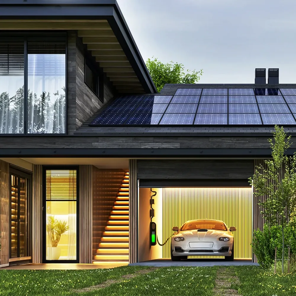 Modern two-story house with rooftop solar panels, illuminated interior, and an electric car charging in an integrated garage at dusk.