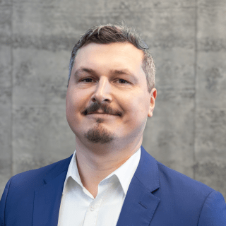 Portrait von Hannes Wolf vor einem grauem Hintergrund.