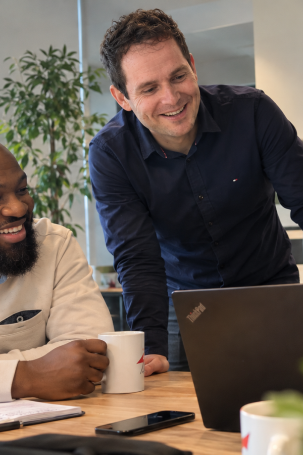 3 men from technical support in an office working front of a computer