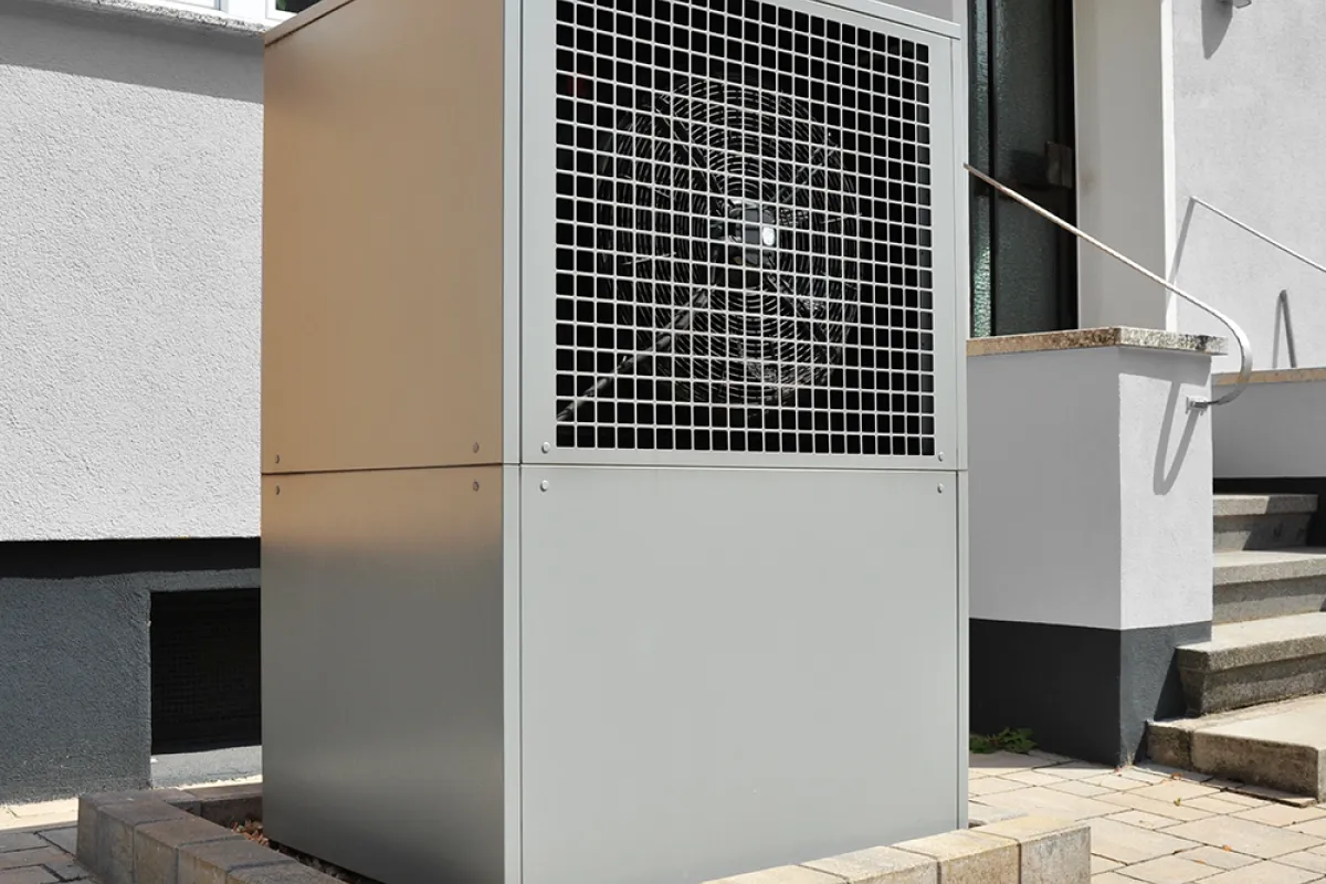 Air source heat pump in front of a house